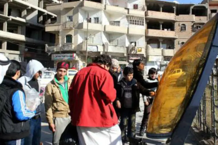Sírios observam destroços de avião jordaniano na região de Raqa, Síria (AFP)