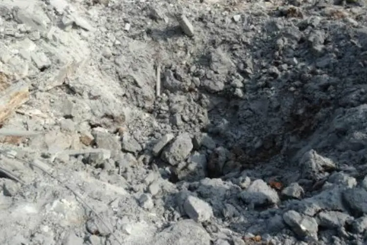 Sírios examinam cratera deixada por ataque aéreo da coalizão chefiada pelos Estados Unidos (Mohamad Zeen/AFP)