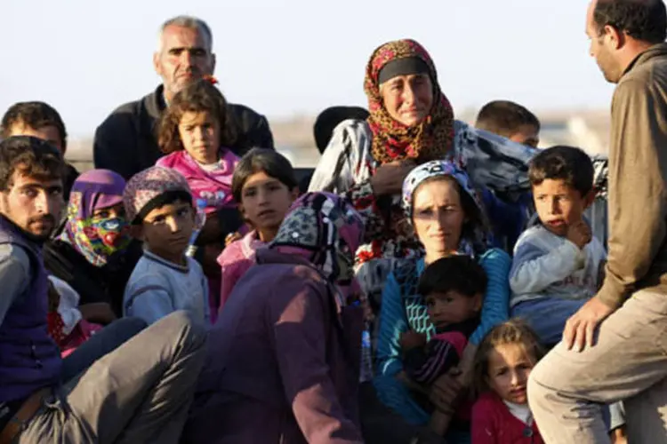 Sírios curdos recém-chegados à Turquia em caminhão fugindo da cidade de Kobani, na fronteira Síria-Turquia (Umit Bektas/Reuters)