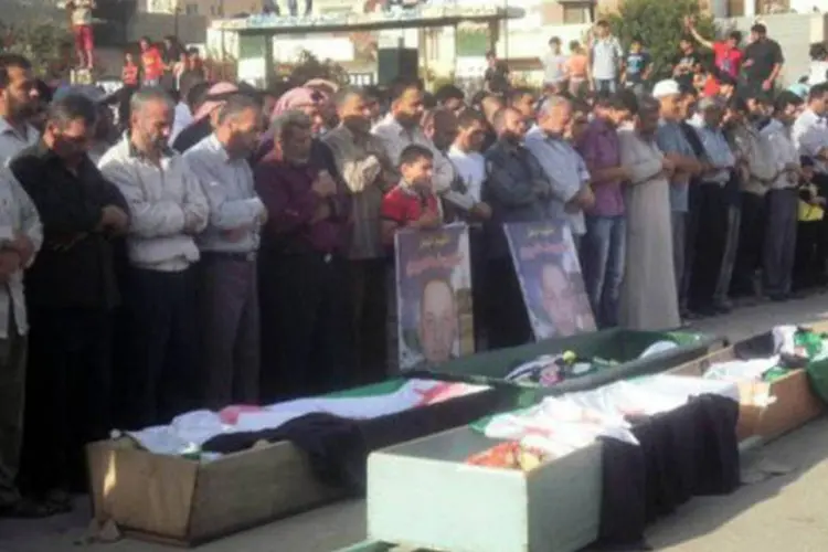 Sírios rezam antes de funeral de pessoas supostamente mortas durante confronto na cidade de Daraa
 (AFP)