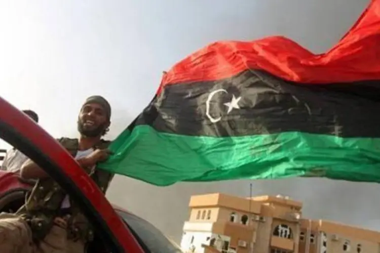 Rebeldes com a bandeira da Líbia em Sirte (Ahmad al-Rubaye/AFP)