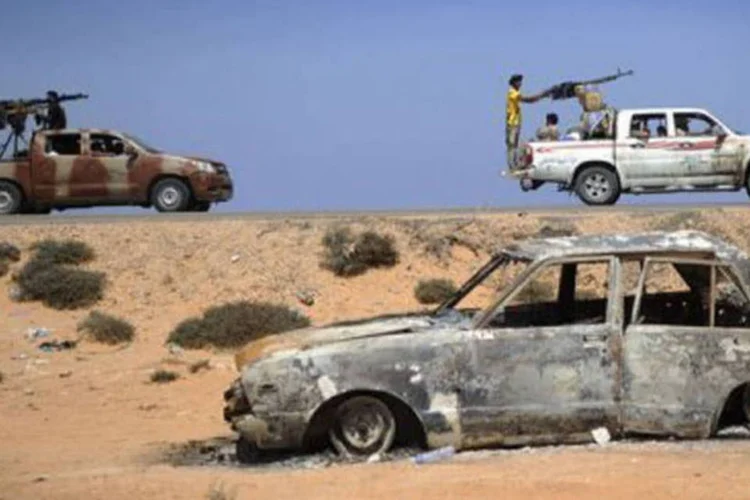 Rebeldes passam por estrada na direção de Sirte (Eric Feferberg/AFP)