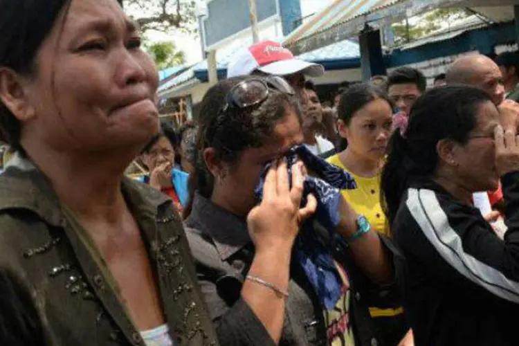 Moradores choram ao ouvir os nomes de seus parentes que conseguiram escapar dos separatistas muçulmanos em Zamboanga, nas Filipinas (AFP)