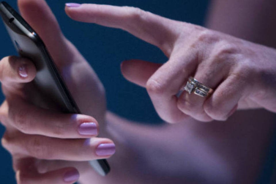 
	Mulher segura smartphone: a Kantar, autora do estudo, diz que tamanho de telas dos smartphones tem influenciado decis&atilde;o de compra do consumidor brasileiro
 (Scott Eells/Bloomberg)