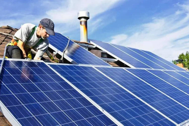 Homem instala painel solar no telhado de casa (Thinkstock/Thinkstock)