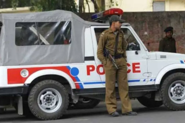 
	Policial indiano diante de sua viatura: pris&atilde;o recorda caso dos corpos esquartejados de 19 pessoas nos canais perto de uma casa de periferia de Nova D&eacute;lhi
 (AFP)