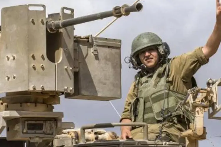 Soldado israelense acena: cortes de energia afetam hospitais, escolas e lojas (Jack Guez/AFP)