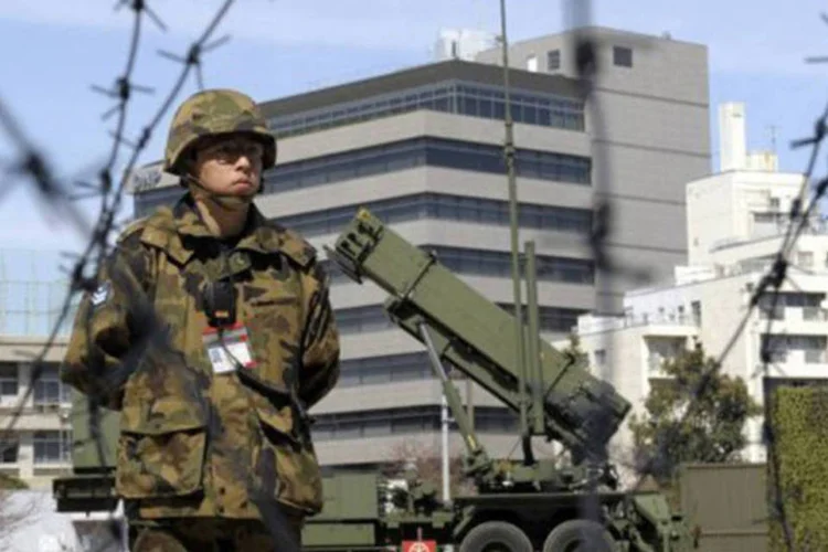 Soldado japonês monta guarda em frente a um lançador de mísseis PAC-3: autoridades japonesas afirmaram que o projétil norte-coreano passaria por Okinawa
 (Toshifumi Kitamura/AFP)