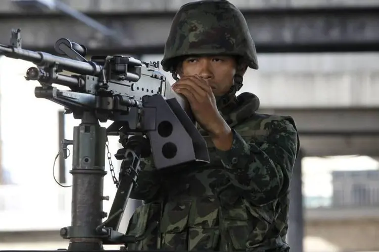 
	Um soldado tailand&ecirc;s caminha em frente &agrave; TV nacional da Tail&acirc;ndia, em Bangcoc
 (Athit Perawongmetha/Reuters)