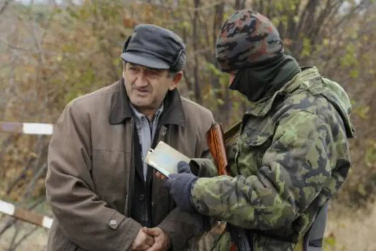 
	Soldado ucraniano verifica a identidade de um homem em um posto no leste do pa&iacute;s
 (Alexander Khudoteply/AFP)