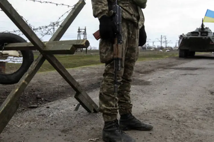 Soldado ucraniano monta guarda ao lado da vila de Salkovo, na região de Kherson, que fica ao lado da Crimeia (Valentyn Ogirenko/Reuters)