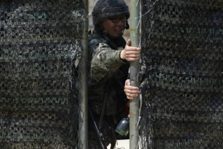 
	Soldados sul-coreano fecha port&atilde;o em um posto de controle: em resposta, as For&ccedil;as Armadas da Coreia do Sul&nbsp;&quot;refor&ccedil;aram sua postura de defesa&quot;&nbsp;caso se produza algum tipo de amea&ccedil;a
 (REUTERS / Lee Jae-Won)