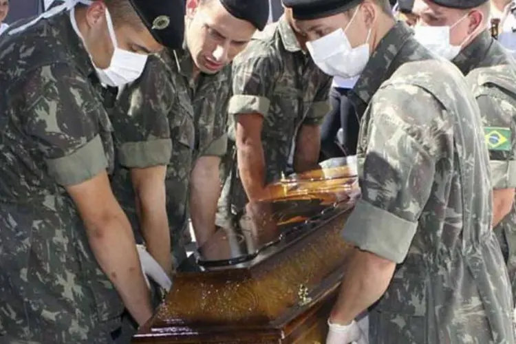Soldados carregam caixão com corpo de uma das vítimas do incêndio (Reuters)