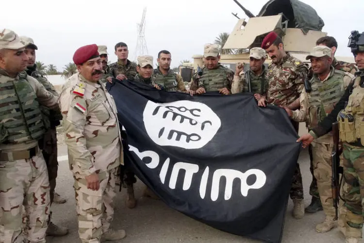 
	For&ccedil;as iraquianas seguram bandeira do Estado Isl&acirc;mico que retiraram de Ramadi ap&oacute;s expulsar o grupo terrorista, dia 1&ordm; de fevereiro
 (Reuters)