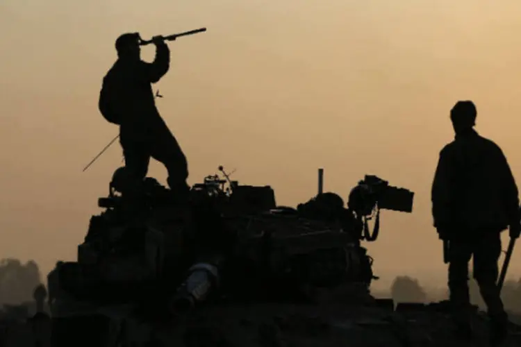 Soldados israelenses em cima de um tanque em uma área de preparação, perto da fronteira com a região central de Gaza  (REUTERS / Darren Whiteside)