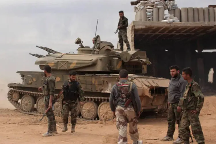 Soldados sírios leais ao presidente Bashar al-Assad perto de um tanque de guerra na região de al-Maamel, no interior de Alepo (George Ourfalian/Reuters)