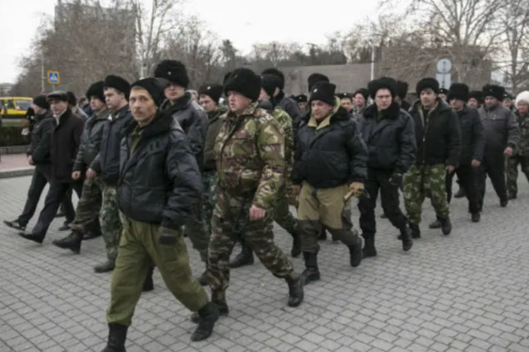 Voluntários da Crimeia e da Rússia que chegaram para ajudar a polícia local marcham na cidade de Sevastopol, na Crimeia (Baz Ratner/Reuters)