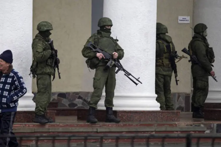 Homens armados montam guarda no aeroporto de Simferopol, na região da Crimeia (Baz Ratner/Reuters)