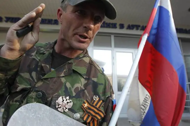 Homem conversa com jornalistas enquanto ativistas pró-Rússia protestam perto da sede regional do Ministério do Interior, em Luhansk, no leste da Ucrânia (Valentyn Ogirenko/Reuters)