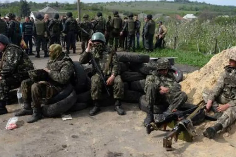 Soldados ucranianos esperam em posto: presidente interino já havia indicado "muitos mortos e feridos" entre os separatistas e a morte de dois soldados (Vasily Maximov/AFP)