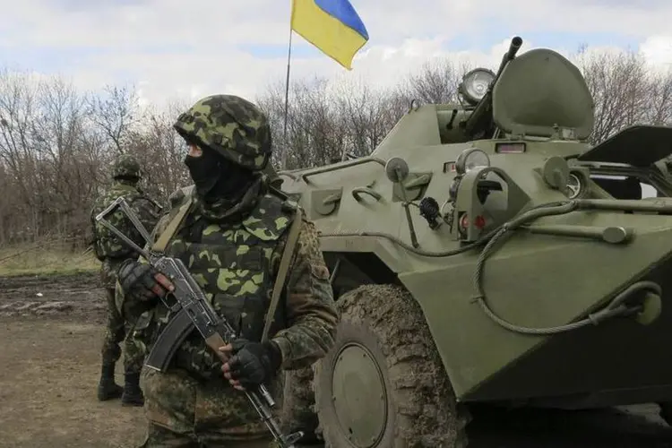 Soldados ucranianos são vistos perto de veículos blindados de transporte de pessoal em um posto de controle perto da cidade de Izium (Dmitry Madorsky/Reuters)