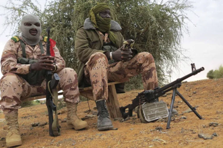 Soldados do Mali sentados em banco na cidade de Gao, que foi recapturada recentemente (Adama Diarra/Reuters)