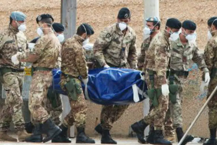 
	Soldados italianos carregam corpo de v&iacute;tima de naufr&aacute;gio: mais de 500 imigrantes foram socorridos na noite de quinta-feira no Canal da Sic&iacute;lia
 (AFP)