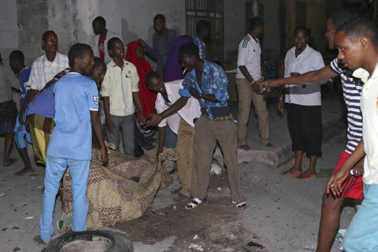 
	Moradores carregam o corpo de uma das v&iacute;timas do ataque ao Hotel Wehelie, na Som&aacute;lia
 (REUTERS/Feisal Omar)