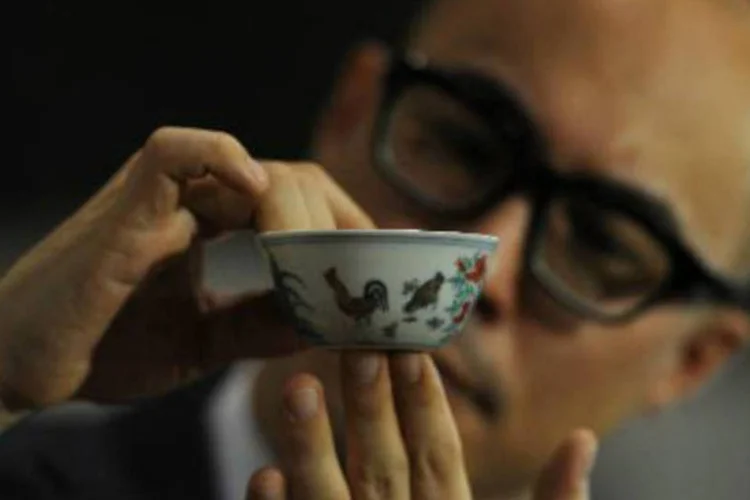 
	Representante da Sotheby&#39;s exibe a tigela da dinastia Ming: a pequena tigela com desenhos policrom&aacute;ticos &eacute; considerada extremamente rara
 (Aaron Tam/AFP)