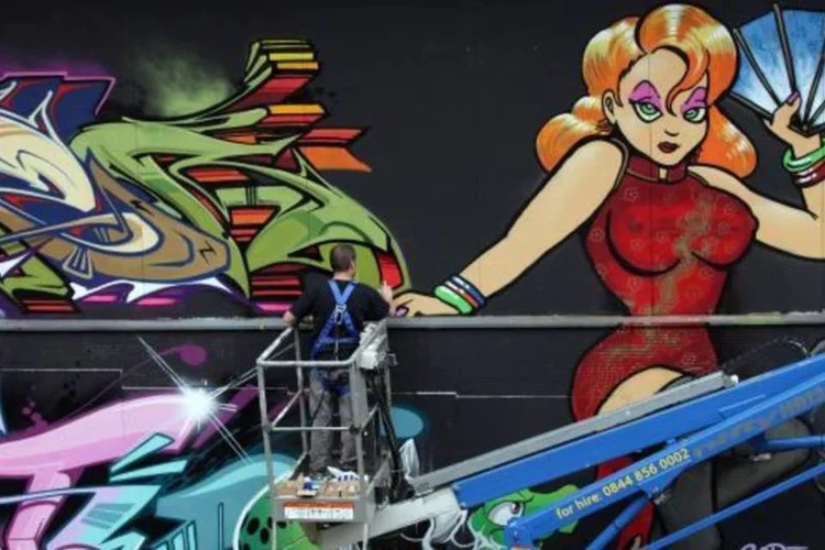 Com ajuda de elevadores, artistas renovam pintura de grafites no festival que ocorre no Reino Unido (Matt Cardy/Getty Images)