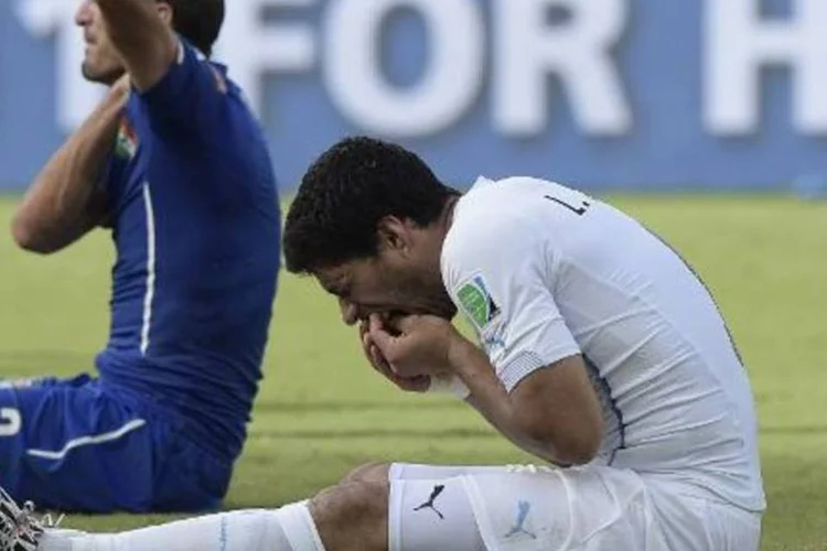 Luis Suárez leva as mãos à boca e Giorgio Chiellini reage após mordida (Daniel Garcia/AFP)