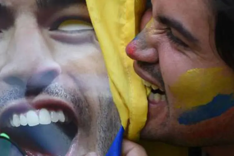 Torcedor morde cartaz com o rosto de Luis Suárez
 (Eitan Abramovich/AFP)