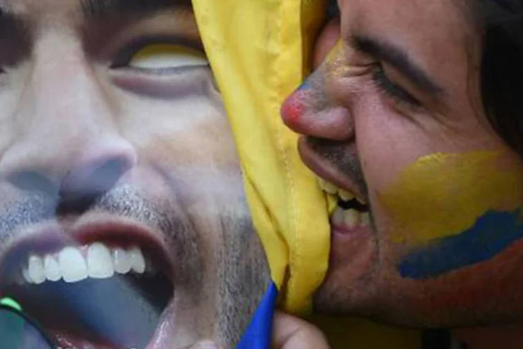 Torcedor morde cartaz com o rosto de Luis Suárez
 (Eitan Abramovich/AFP)