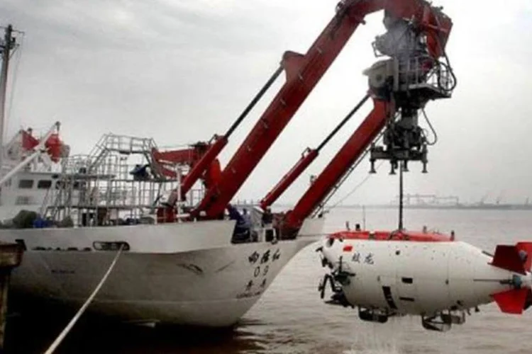 Um guindaste ajuda a colocar o 'Jiaolong' no mar de Huanghai. (AFP)
