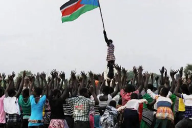 Com a bandeira do Sudão do Sul, jovens ensaiam uma coreografia e comemoram a independência do país, que será proclamada neste sábado (Paul Banks/AFP)