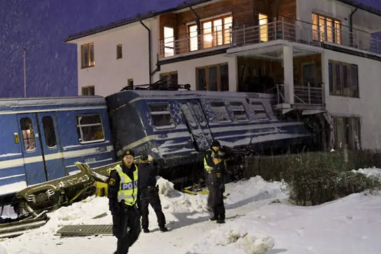 
	Policiais ficam ao redor do local onde um trem descarrilou e invadiu uma casa em Saltsjobaden, Estocolmo
 (Jonas Ekstromer/Scanpix Sweden/Reuters)