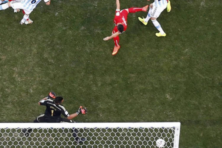 
	Meio-campo su&iacute;&ccedil;o Blerim Dzemaili durante cabeceio contra a Argentina
 (Pawel Kopczynski/Reuters)