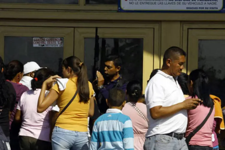 
	Seguran&ccedil;a tenta manter a ordem na entrada de um supermercado na Venezuela
 (Juan Carlos Hernandez/Bloomberg)