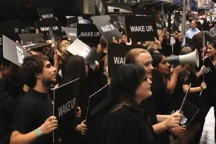 O grupo de "manifestantes" uniformizados agitava cartazes e gritava a frase "Acorde!" em frente à loja da Apple em Sydney, Austrália (Reprodução)