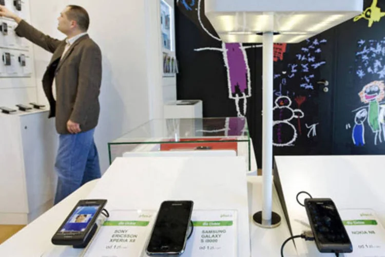 Consumidor olha celulares em uma loja da Plus GSM, operada pela Polkomtel, uma das empresas do biolionário polonês Zygmunt Solorz-Zak, em Warsaw, na Polônia (John Guillemin/Bloomberg)