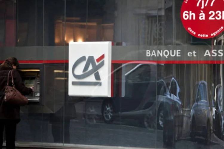 Mulher usando o caixa-eletrônico de uma agência do Credit Agricole em Paris: banco quer focar a sua estratégia mais no mercado doméstico (Balint Porneczi/Bloomberg)