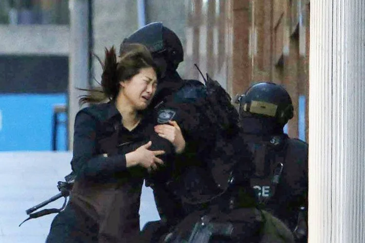 
	Ref&eacute;m corre em dire&ccedil;&atilde;o a policiais ap&oacute;s fugir de loja Lindt em Sydney, Austr&aacute;lia, onde sequestrador armado mant&eacute;m outras pessoas
 (Jason Reed / REUTERS)