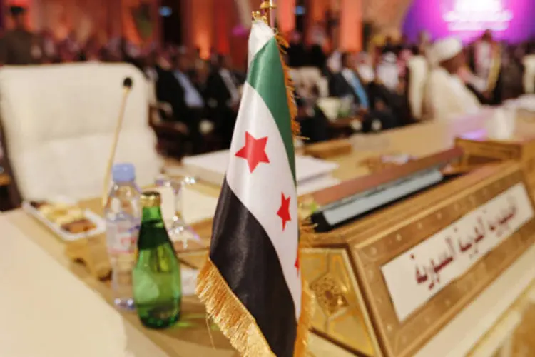 
	Bandeira da oposi&ccedil;&atilde;o &eacute; vista em frente a cadeira da delega&ccedil;&atilde;o da S&iacute;ria na abertura do encontro da Liga &Aacute;rabe em Doha
 (Ahmed Jadallah/Reuters)