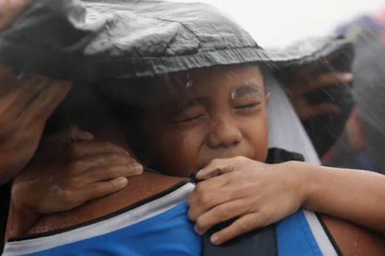 
	Menino no colo do pai tenta se proteger da chuva enquanto aguarda resgate nas Filipinas: governo&nbsp;admitiu o&nbsp;&quot;pesadelo log&iacute;stico&quot;&nbsp;que se tornou a gest&atilde;o do desastre
 (Getty Images)