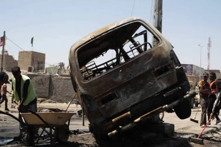 
	Equipe limpa local onde aconteceu um atentado com carro-bomba em Basra, Iraque: grupo disse que seus membros fizeram atentados contra edif&iacute;cios do governo, delegacias da pol&iacute;cia e sedes militares
 (Stringer/Reuters)