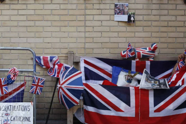 
	F&atilde; na parte de fora da maternidade onde Kate Middleton &eacute; aguardada: fato de o casal se instalar na casa dos pais dela leva a crer que beb&ecirc; pode nascer no hospital local, e n&atilde;o em Londres
 (Suzanne Plunkett/Reuters)