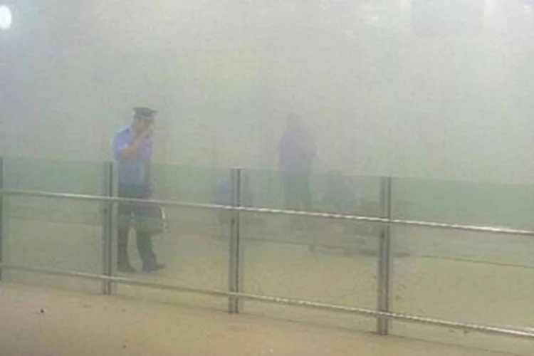 Policial caminha por fumaça causada por detonação de bomba caseira no aeroporto de Pequim: após o incidente, que causou dois feridos, autoridades instalaram novos controles de explosivos nos acessos às salas de entradas e saídas dos aeroportos (China Stringer Network/Reuters)