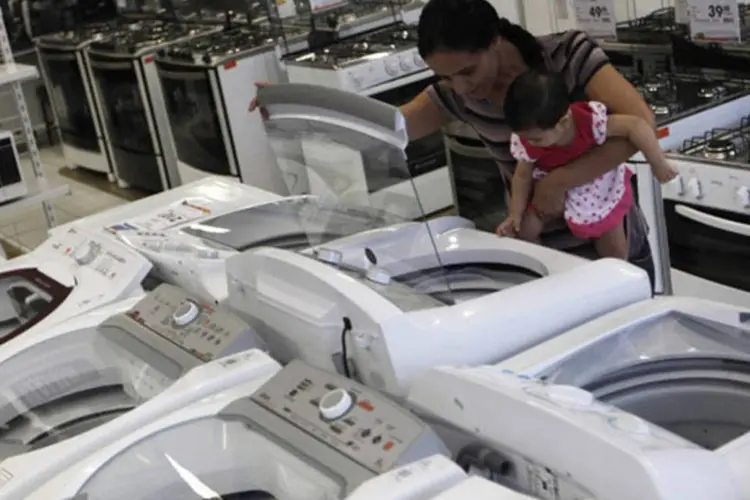 Mulher com filha examina uma máquina de lavar em loja de São Paulo: todos os itens que compõem o indicador tiveram variações positivas em junho, exceto perspectiva profissional, que registrou -3,8% (Nacho Doce/Reuters)