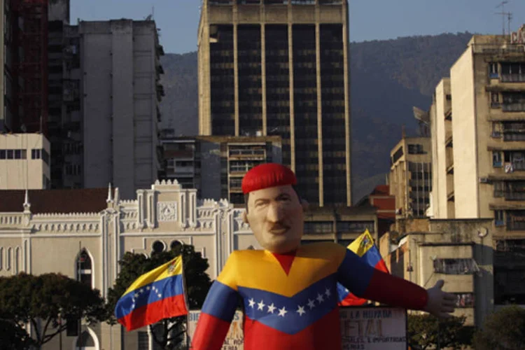 
	Figura infl&aacute;vel do presidente venezuelano Hugo Ch&aacute;vez em Caracas:&nbsp;vendedores ambulantes percorrem a regi&atilde;o vendendo cartazes, bandeiras e fotos de Ch&aacute;vez.
 (Jorge Dan Lopez/Reuters)