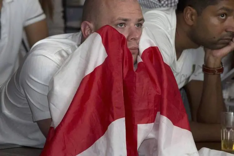 
	Torcedor ingl&ecirc;s assiste derrota da Inglaterra com bandeira em m&atilde;os
 (Neil Hall/Reuters)